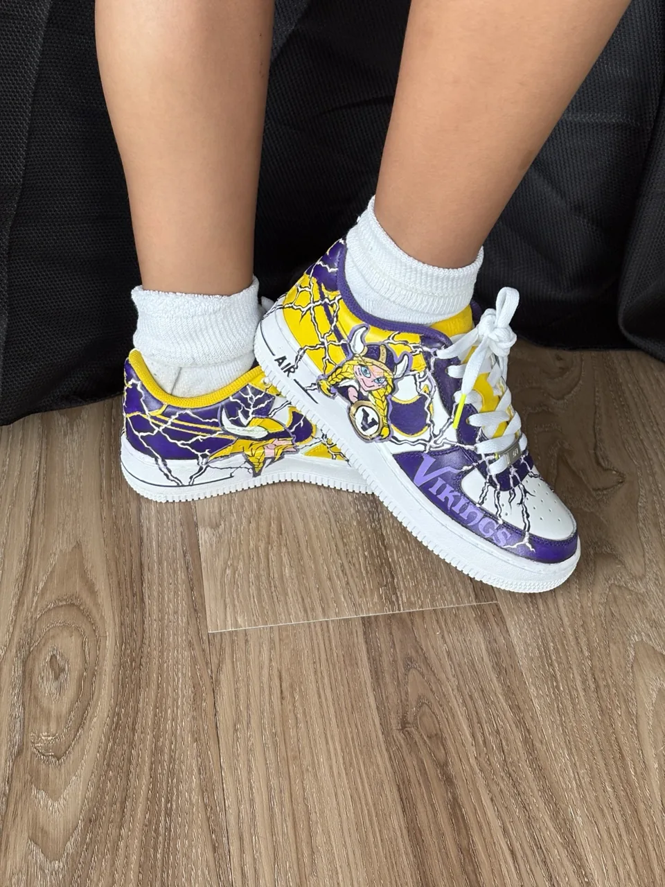 Side view of both shoes showing purple-and-gold painted details